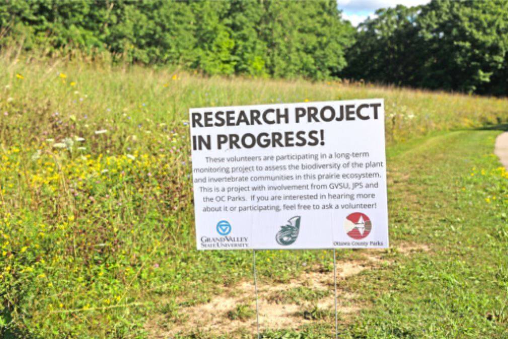 Sign about in progress research in the middle of a field